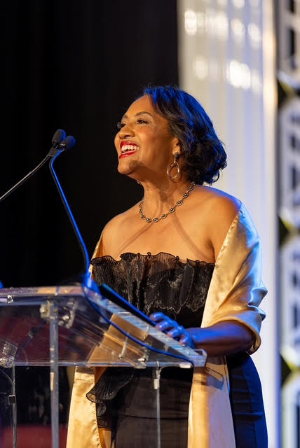 CEO, Speaker, and Poet Sonya Kay Blake inspiring a crowd of 600 people speaking at the podium at a black-tie gala.